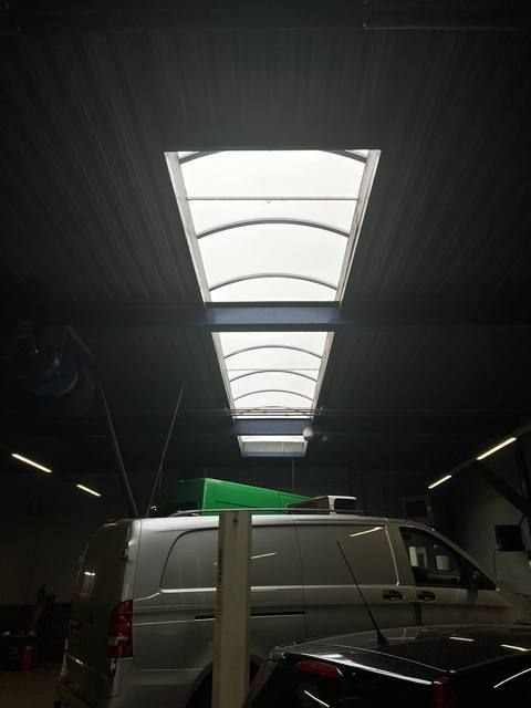 Detailshot gebogen polycarbonaat lichtstraat van binnenuit, wit doorschijnend daglicht