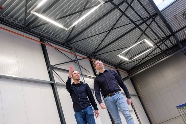 Medewerkers aan het werk in een bedrijfshal met daglicht via lichtstraten