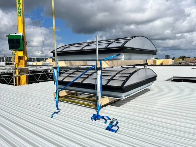 Afgewerkte gebogen lichtstraten in rijen op metalen dak NS treinstelhallen