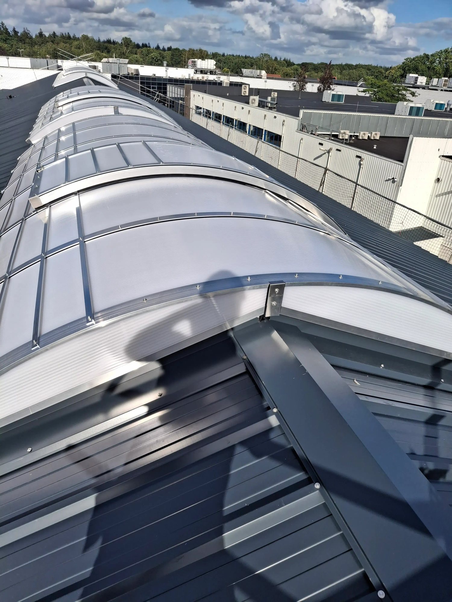 Lange gebogen lichtstraat op bedrijfsdak Materieeldienst 2026