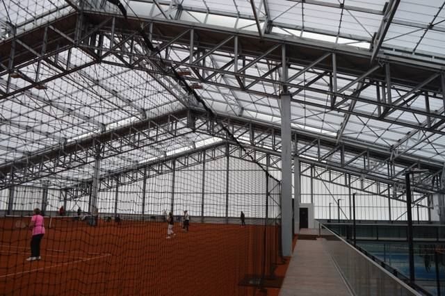 Interieur tennishal Etten-Leur met lange rijen lichtstraten die gelijkmatig daglicht verspreiden