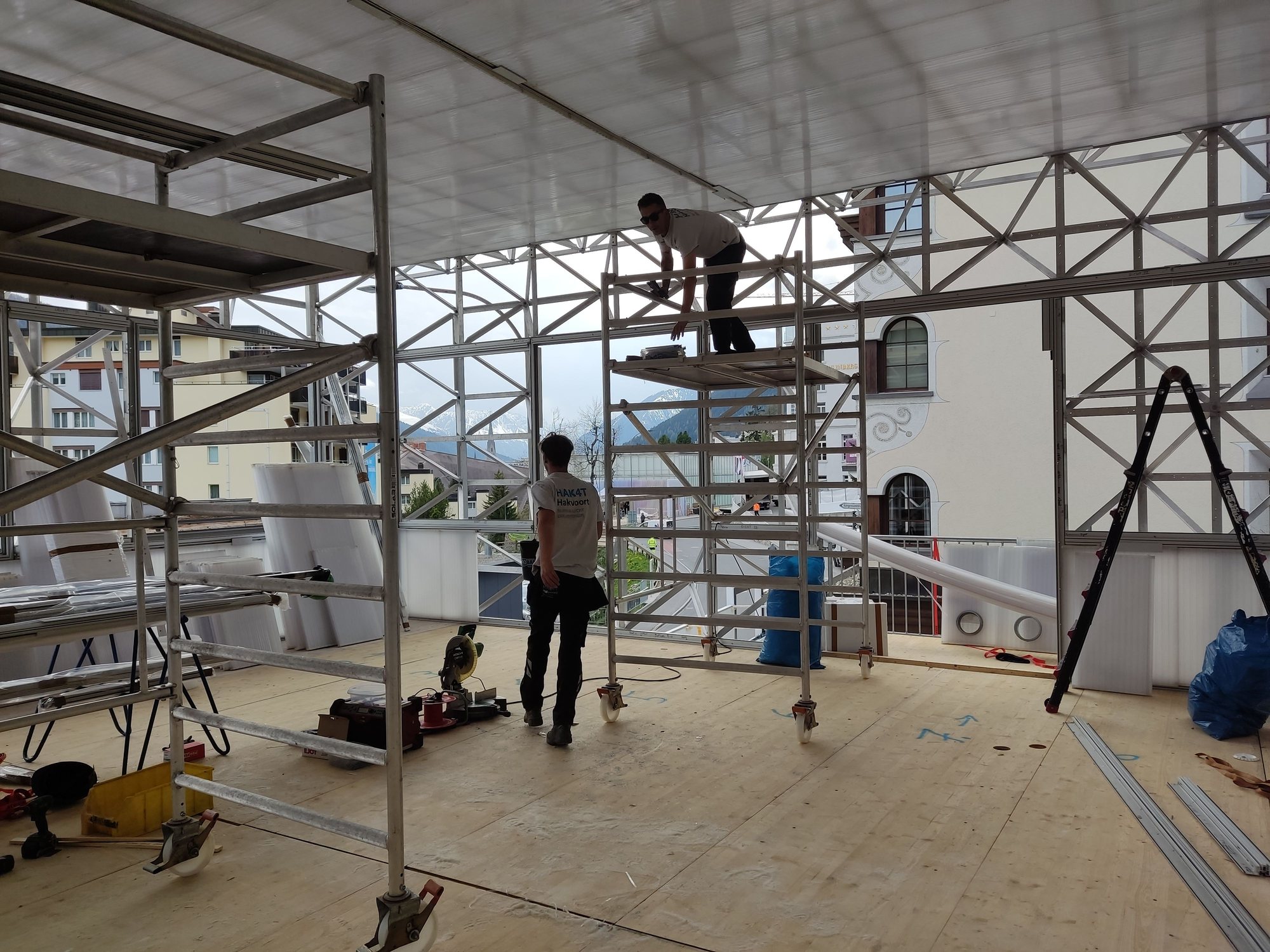 Monteurs plaatsen translucente panelen in groot metalen frame, ICE House Davos 2022