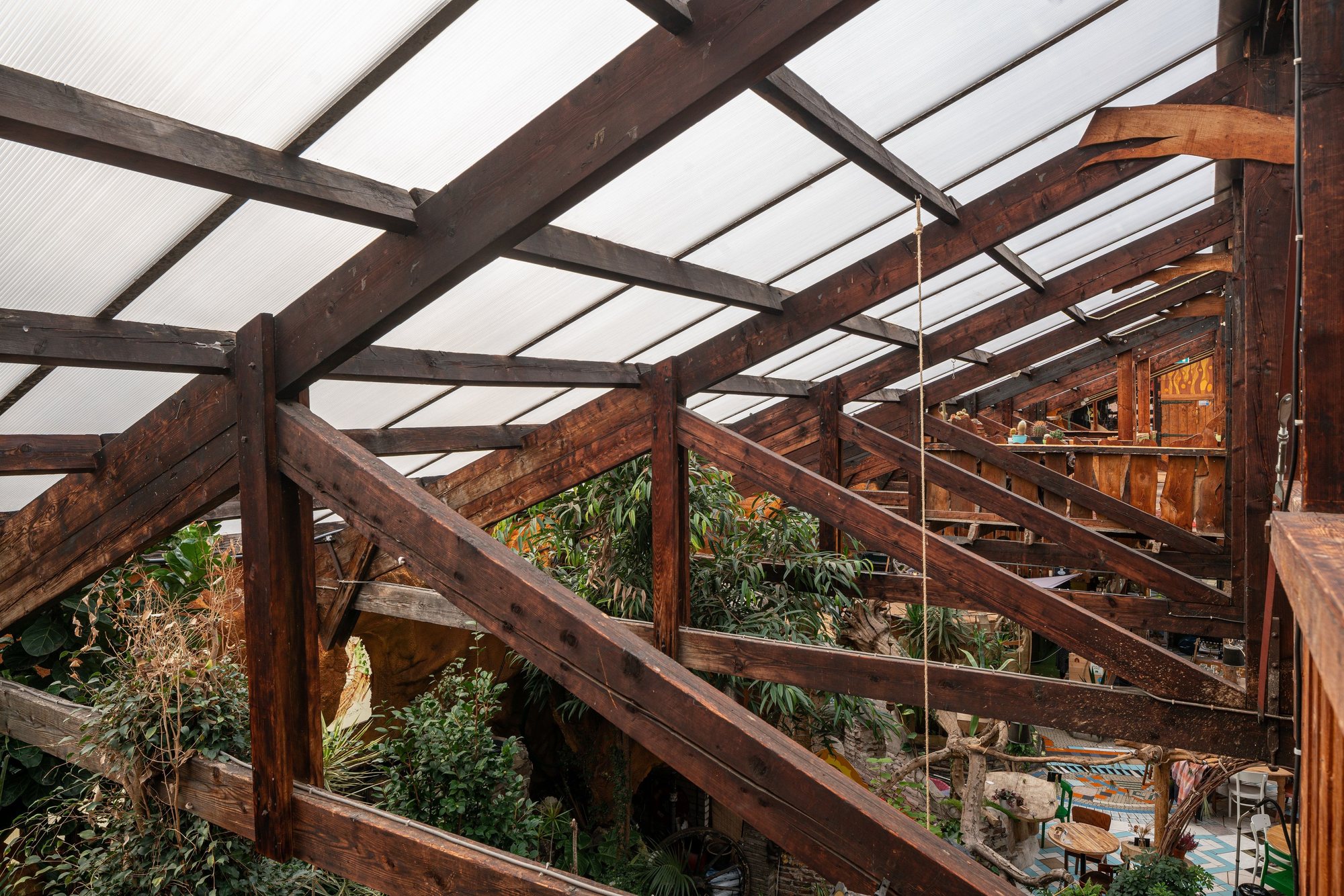 Kruisende houten liggers met glazen dakvlakken boven een binnentuin, Het Paradijs Enschede