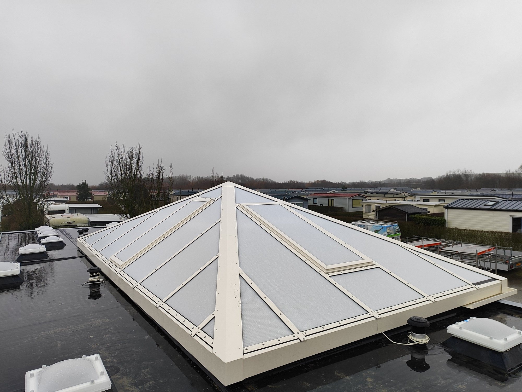 Brede piramidekap met ventilatiedelen op bedrijfsdak 2024