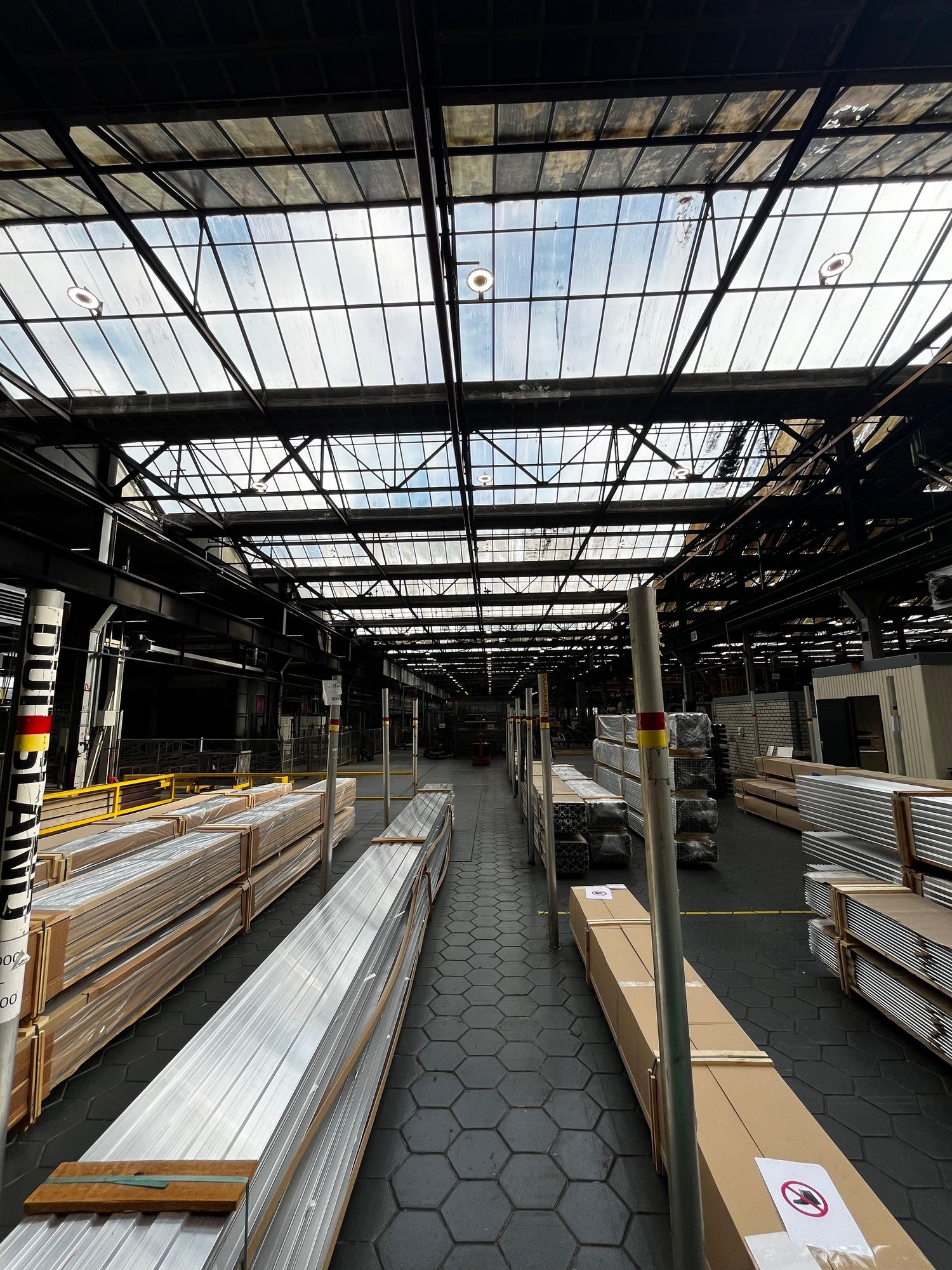 Interieur langs een rij lichtstraten in het dak van een industriële hal met helder daglicht