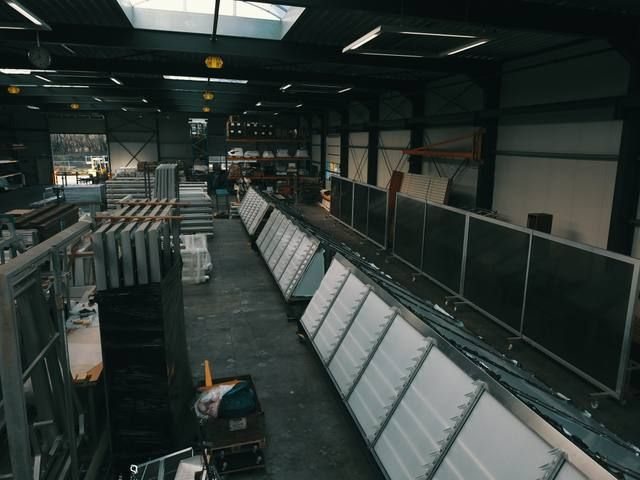Rijen prefab sheddak-elementen in de hal met daglicht dat van de daklichten binnenvalt