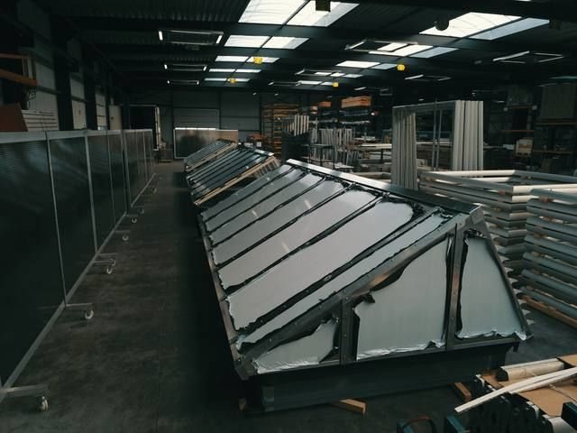 Groot prefab sheddak-element diagonaal door de productiehal met sterke dieptewerking