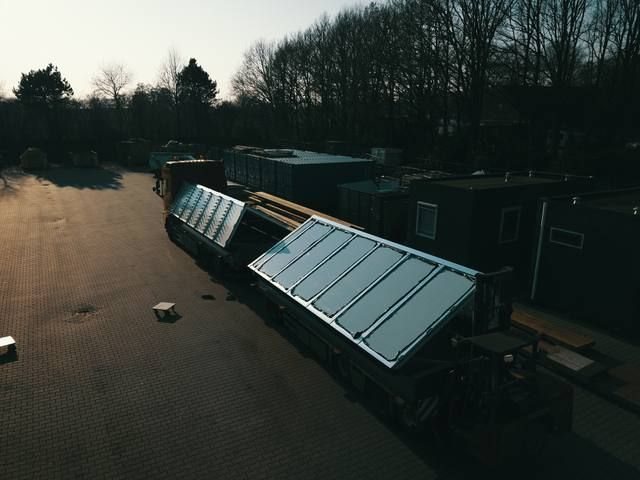 Prefab sheddak-element op een dieplader-trailer in laag winterzonlicht