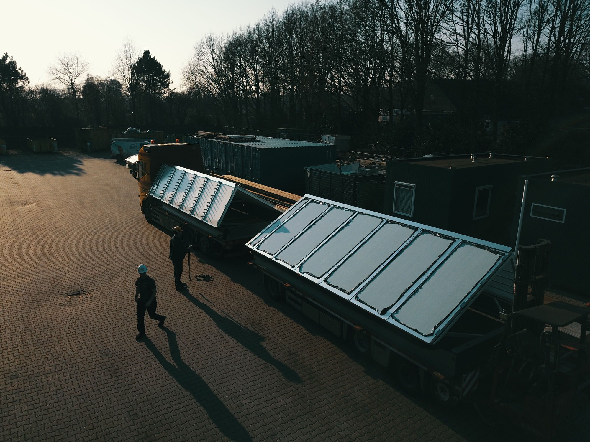Sheddak-element op dieplader met monteur ernaast, Azalea Amsterdam